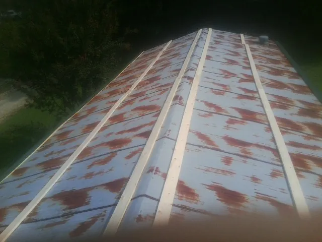 Rusted metal roof panels with new wood purlins before replacement — Storm Damage Roof Repair in Milldale by Roofing Brothers