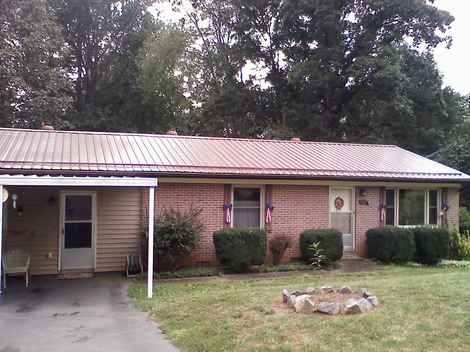 Bronze metal roof and carport on a brick ranch home — Roof Repair work by our crew in Milldale