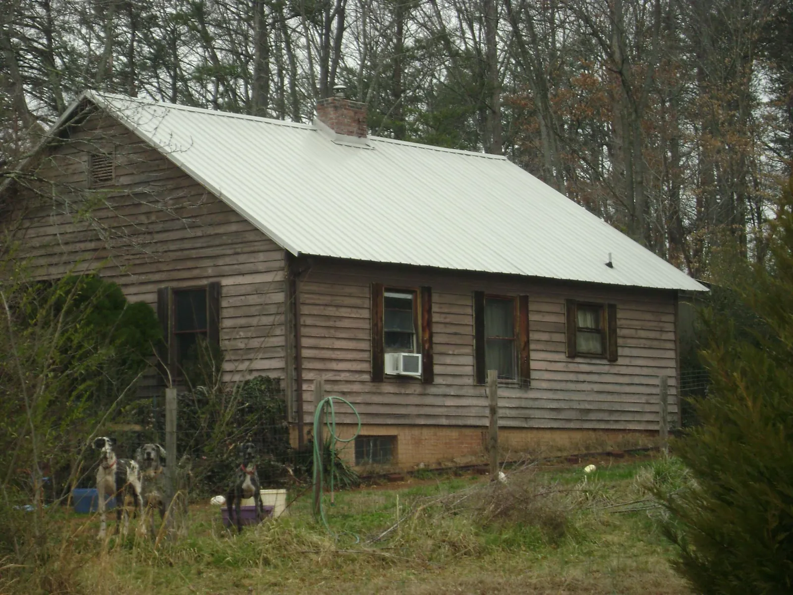 White metal roof on an old wood sided farmhouse, from a Metal Roof Installation job in Milldale